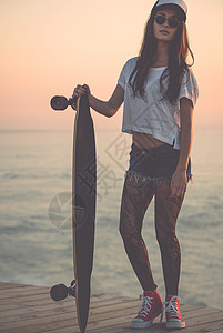 斯卡特女孩运动木头滑冰乐趣日落溜冰者潮人海滩太阳镜木板图片