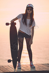斯卡特女孩滑冰长板街道冒充乐趣日落海滩女性赃物骑术图片