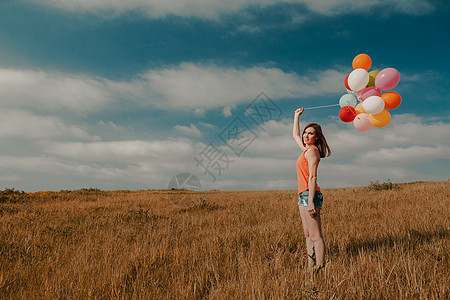 Ballons 女孩带Ballons幸福旅行晴天乐趣喜悦气球草地场地天空波动图片