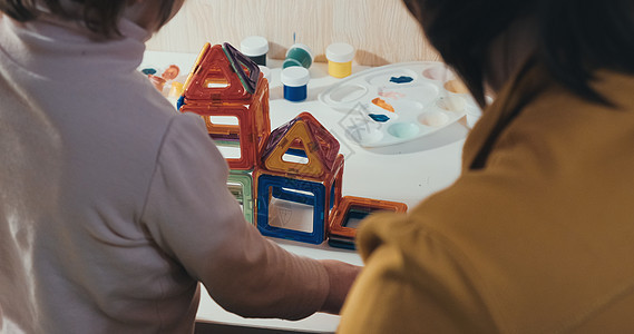 与母亲一起生孩子的妈妈收集一个磁建构器 闭合镜头 后视孩子们教学托儿所幸福房子训练工艺家庭关系女士儿童图片