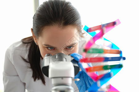 一位女性生物学家透过显微镜看一眼图片