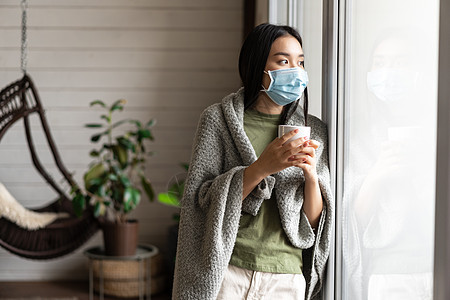 身戴医疗面罩的亚裔女孩 渴望外出 患上19岁胎儿病和在家中进行自我隔离疾病肺炎痛苦发烧毯子杯子鼻子女性房子疼痛图片