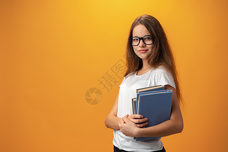戴眼镜的聪明少女拿着黄色背面的书笔记本孩子们青少年潮人微笑知识学习科学教育大学图片