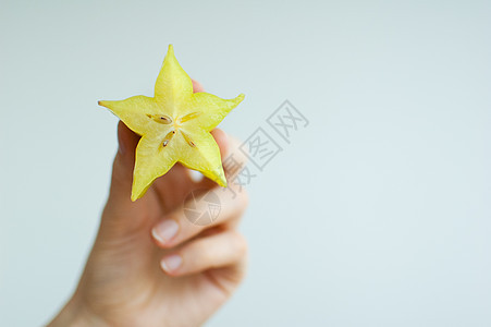 女性手握着奇特的成熟恒星水果或香草果 健康食品 新鲜有机星苹果水果食物星星营养橙子异国饮食手臂农业姿势热带图片