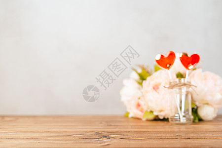 静物情人节节日空背景与 2 红色棒棒糖和粉红色的花朵在木桌背景 带有复制空间的样机用于设计 离焦横幅图片