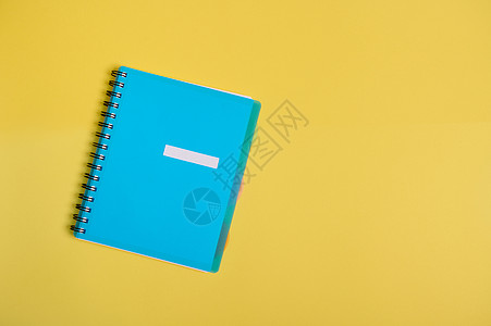 平躺的办公用品 蓝色彩色组织者 带空白空白纸的记事本 隔离在黄色背景上 带复制空间图片