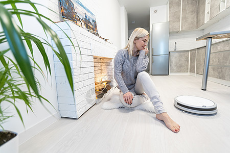 使用自动真空吸尘器清洁地板 控制智能机器家务机器人的年轻女性房间器具家政拖把家庭灰尘清扫汽车技术清洁工图片