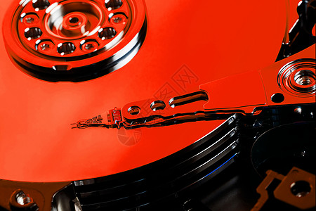 电脑HDD的硬盘是红色的 有镜面效果 计算机的硬盘驱动器已打开技术硬件磁盘驾驶电子电缆贮存圆柱反射宏观图片