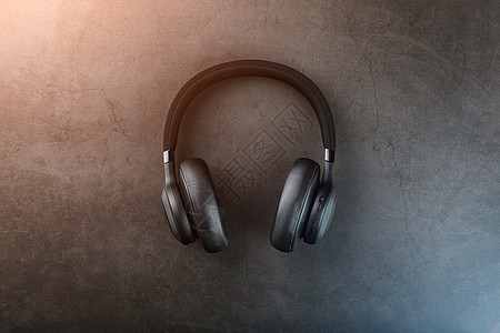 黑色蓝牙耳机在暗底背景上 有蓝色和橙色背光 DJ 的耳内耳语白色技术电子收音机娱乐电缆配饰工作室耳朵电气图片
