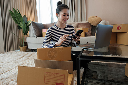 年轻的亚洲女企业家 青少年早上在家里用电脑工作 幸福的女人微笑着为她的工作 中小企业在家工作的概念电子商务女孩命令物流成人船运店图片