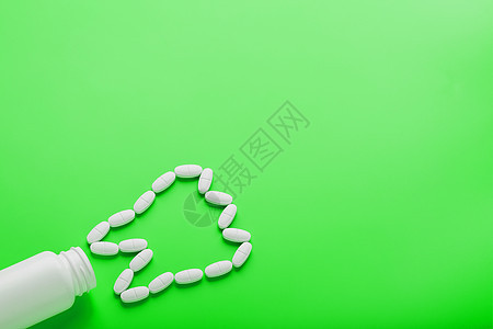 在绿色背景的白色罐子上洒出的牙齿 以维生素钙的形式呈现出来药品医生蓝色止痛药矿物质处方治疗维生素疼痛制药图片