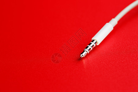 红色背景的白色连接器 AUX 白电线电话数据力量电子电气立体声插头黑色电脑耳机图片