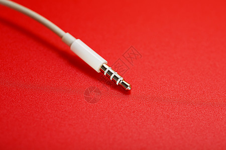红色背景的白色连接器 AUX 白电线电子耳机立体声力量插头电话绳索扬声器电脑互联网图片