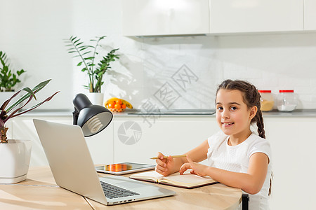 孩子们远程学习 可爱的小女孩在家里使用笔记本电脑 教育 在线学习 家庭学习 技术 科学 未来 远程学习 家庭作业 女学生生活方式图片