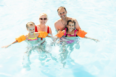 快乐的家庭在游泳池玩耍 暑假概念水池男生闲暇儿子男人假期乐趣女性戏服女孩图片