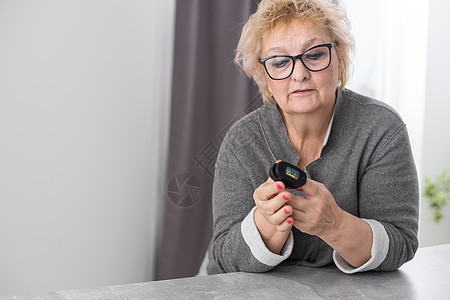 指尖附有脉搏血氧计的老年妇女手 老年测量心率 检查血液中的氧饱和度 冠状病毒的诊断 家中的COVID19脉冲速度女士监控治疗疾病图片