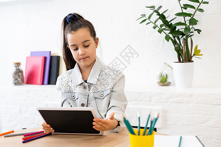 教育 小学 学习 技术和人的概念-带平板电脑的小女孩图片