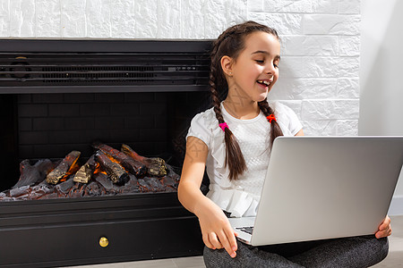 孩子们远程学习 可爱的小女孩在家里使用笔记本电脑 教育 在线学习 家庭学习 技术 科学 未来 远程学习 家庭作业 女学生生活方式图片
