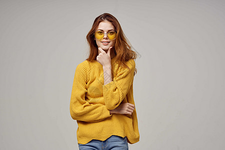 穿着黄色毛衣时装眼镜工作室模特的红头发女人图片