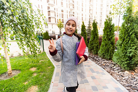 学校俱乐部 现代教育 私立学校 背着背包的青少年 时尚微笑的女学生 女孩小时尚女学生背着背包学校建筑背景 女学生的日常生活图书街图片