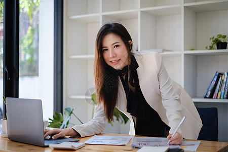 亚洲商业妇女致力于分析技术物价图表和指标 账户或储蓄资金或保险概念 并努力进行这方面的分析笔记本金子抵押预算财富退休投资帐户生长图片