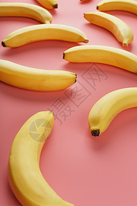 粉红色背景的香蕉几何图案 从顶部看流行团体营养小吃横幅艺术饮食热带墙纸情调图片