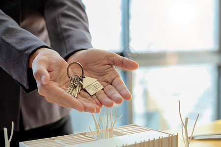 房地产代理商交出房屋钥匙 并提交经核准的抵押贷款申请表和握手的房用钥匙房子戒指建筑经纪人成功抵押交易夫妻合同投资图片