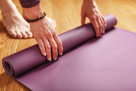一个女孩在在家用木制地板做锻炼前 铺了长袍瑜伽垫子美体福利爱好健康女士成人活动运动闲暇地面图片