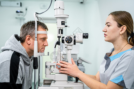 眼科诊所的医生和病人 男性患者用特殊眼科设备检查视力 验光概念 拜访眼镜商的人 配镜师或验光师裂隙灯的病人男人实验室女性机器诊断图片