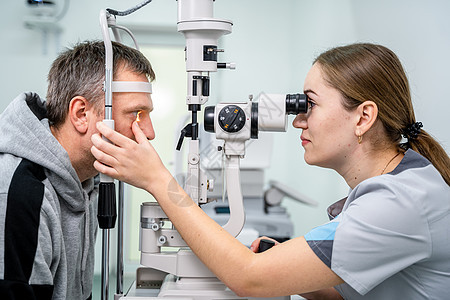 眼科诊所的医生和病人 男性患者用特殊眼科设备检查视力 验光概念 拜访眼镜商的人 配镜师或验光师裂隙灯的病人房间职业医学保健男人治图片