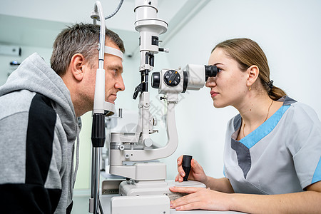 眼科诊所的医生和病人 男性患者用特殊眼科设备检查视力 验光概念 拜访眼镜商的人 配镜师或验光师裂隙灯的病人眼睛医师药品青光眼访问图片
