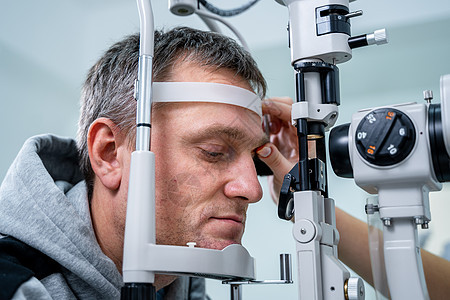 验光师在现代眼科诊所检查男性患者的眼睛 在现代诊所检查期间与男病人的眼科医生 验光概念 诊所视力检查职业女性房间器材访问测试医院图片