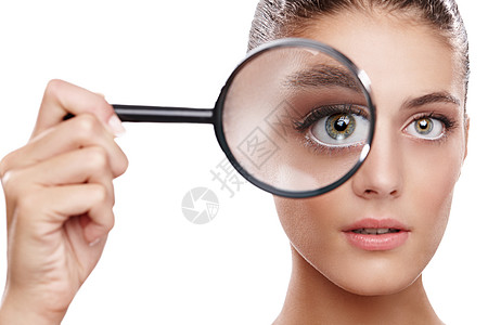 摄影棚拍到一个美女的镜头 在她眼皮子前拿着放大镜 她的眼睛在看她图片