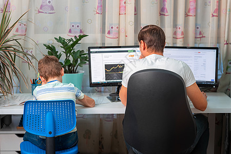 有孩子的父亲在隔离期间试图在家工作 呆在家里 在冠状病毒期间从家庭概念开始工作桌子电脑办公居家儿子女孩办公室自由职业者男生女儿图片