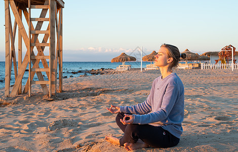 年轻健康的女人 在日出时在海滩上做瑜伽运动活力冥想身体沉思成人天空女性海洋生活图片