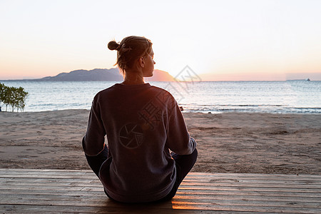 年轻健康的女人 在日出时在海滩上做瑜伽身体天空女性女士生活成人训练平衡日落运动图片