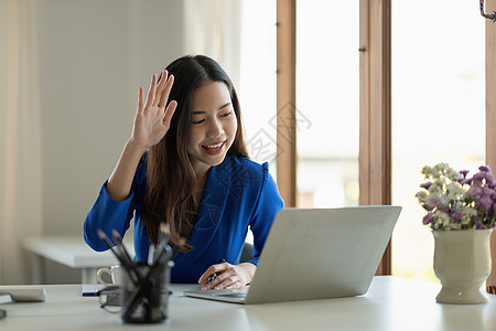 亚洲女商务人士使用笔记本电脑与同事通过视频电话交谈计划 同时在客厅在家工作时机智 自我孤立 社会不安定 预防冠状病毒的隔离等情况图片