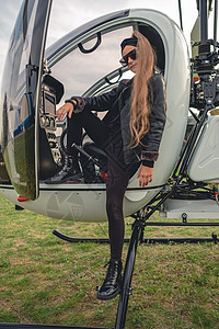 自信的黑衣女孩站在直升机的脚踏板上图片