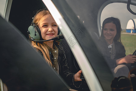 坐在直升机驾驶舱的飞行员头顶上微笑的Tween女孩图片