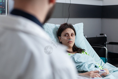 在医院病床上接受手术后康复的妇女 在医生解释治疗方案时看起来很乐观图片