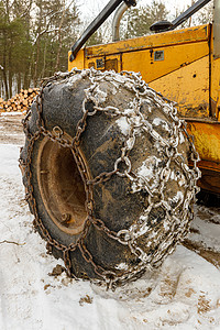 特写黄伐木滑雪机上的冬季链车辆安全拖拉机建筑机器牵引力风险集材机木头林业图片