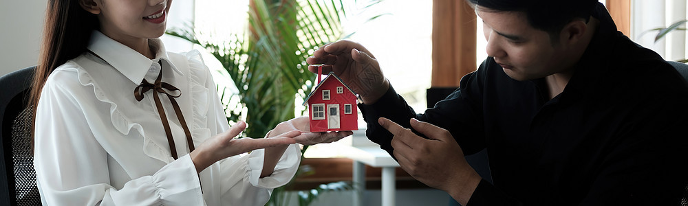 亚洲夫妇正在用手保护房地产投资者 租赁保险 买卖合同和维护中使用手势的概念 横幅图片