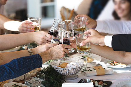 庆祝 饮食和节日概念     手缠葡萄酒杯快乐玻璃桌子午餐服务员团体家庭派对男人奢华图片