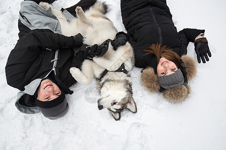 美丽的家庭 一个男人和一个女孩与狗一起在冬季森林玩狗西伯利亚哈斯基女士快乐朋友假期宠物公园笑声男人动物闲暇图片