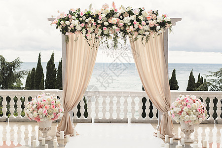 婚礼仪式的豪华地区 有盛装花朵的结婚拱门 在婚礼上背景图片