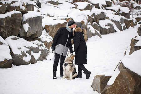 美丽的家庭 一个男人和一个女孩与狗一起在冬季森林玩狗西伯利亚哈斯基松树宠物女士女孩快乐动物公园笑声朋友石头图片
