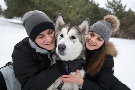 美丽的家庭 一个男人和一个女孩与狗一起在冬季森林玩狗西伯利亚哈斯基喜悦女士女性夹克动物快乐乐趣笑声朋友宠物图片