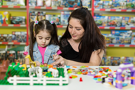 有个小女儿在玩砖块的妈妈玩具母亲学习父母家庭创造力幼儿园乐趣活动女性图片