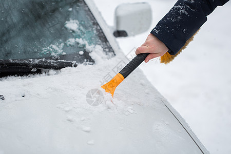 女人在冬天从车里擦雪划痕车辆冻结窗户扫帚玻璃安全运输降雪季节图片