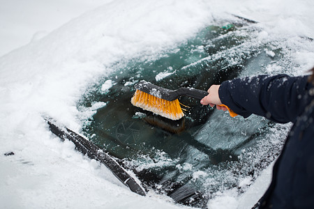 雪汽车一个女人从车挡风玻璃上取下雪天气汽车女性工具刮刀季节降雪划痕玻璃风暴背景